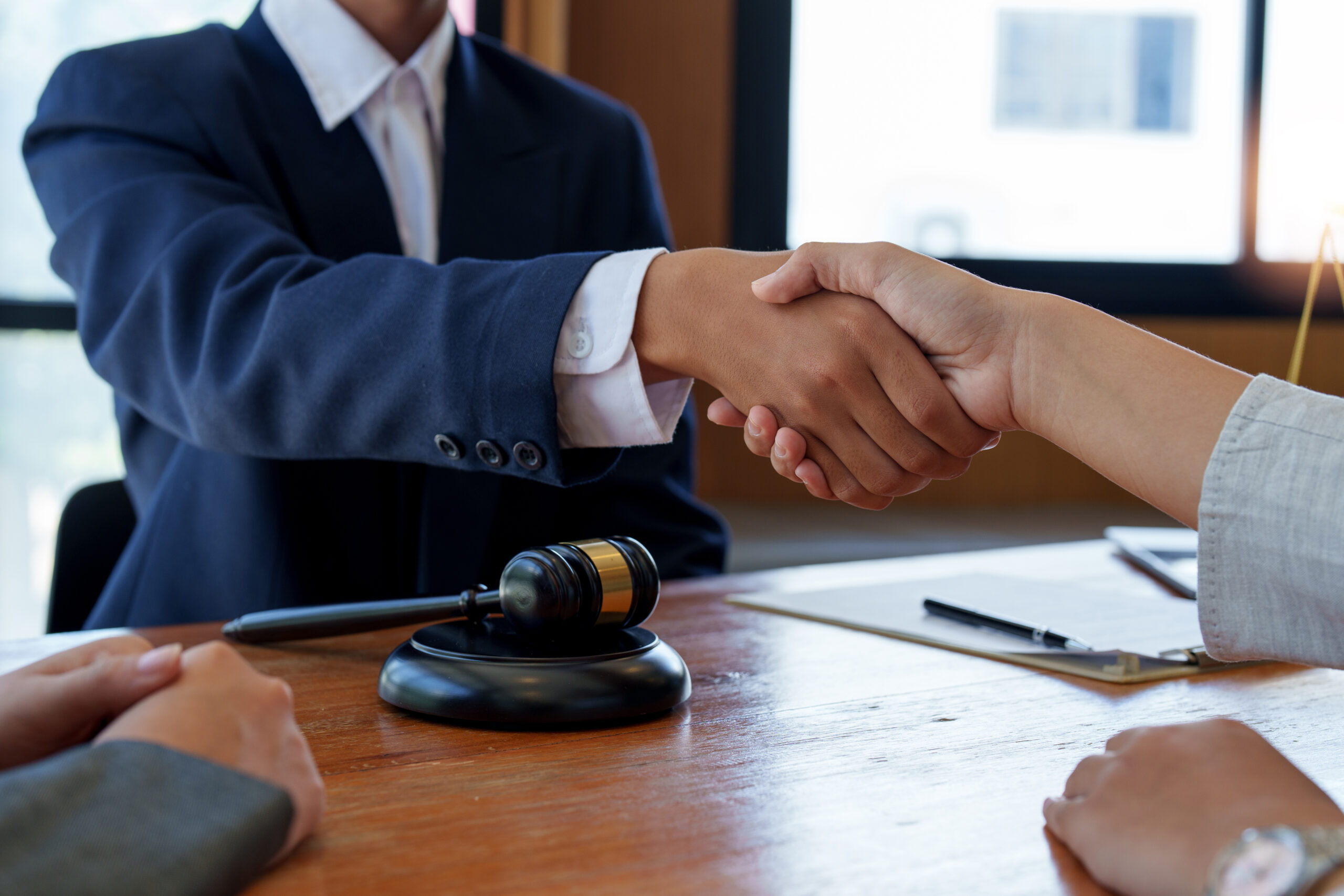 Businessman shaking hands to seal a deal with his partner lawyers or attorneys discussing a contract agreement.